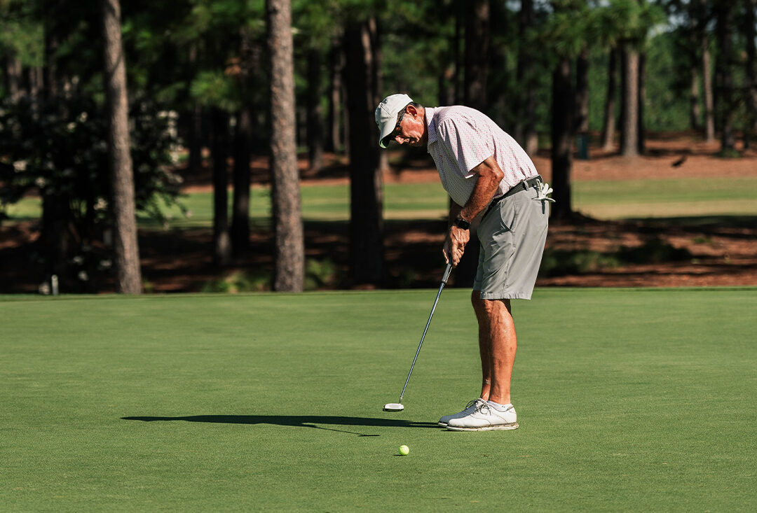 North & South Senior golfer putting