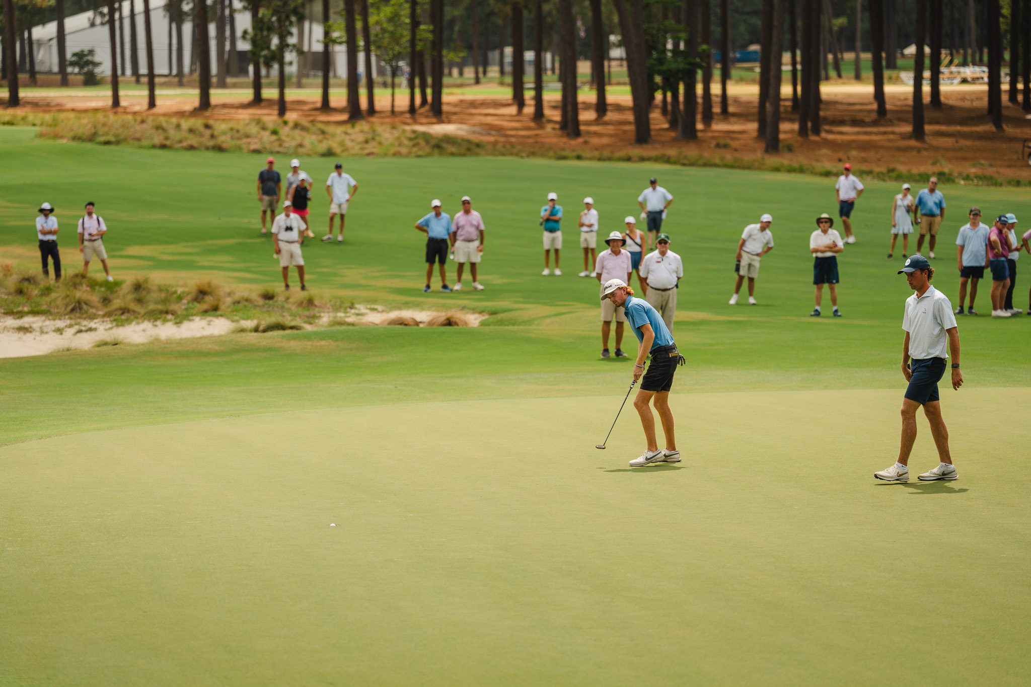 Davis Ovard makes a birdie on the 12th hole of Pinehurst N0. 2 as Jackson Van Paris looks on during the championship match of the 124th North & South Men's Amateur on Saturday.