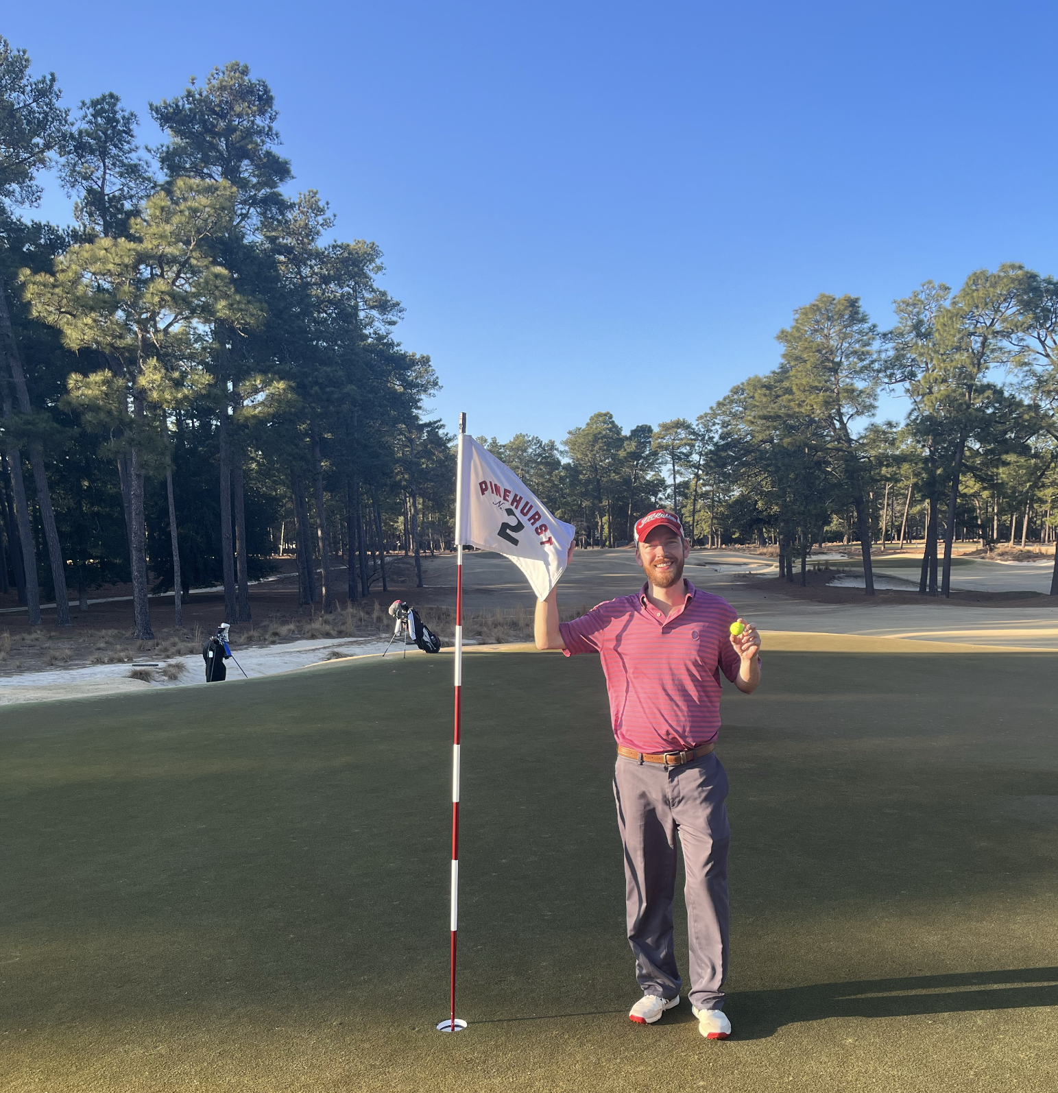 Kent Hubbard poses with the flag and his father's yellow Titleist AVX after making a hole-in-one on the 17th hole of Pinehurst No. 2, played on the 1-year anniversary of Bill's passing.